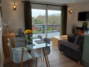 a living room with a table and a couch at Chalet 176 Glan Gwna Park Caernarfon in Caeathro
