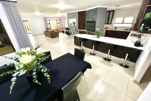 斯瓦科普蒙德Crossroads Luxury Accommodation的厨房里有一张桌子，桌子上放着一瓶花