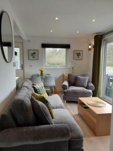 ein Wohnzimmer mit einem Sofa und einem Tisch in der Unterkunft Chalet 176 Glan Gwna Park Caernarfon in Caeathro