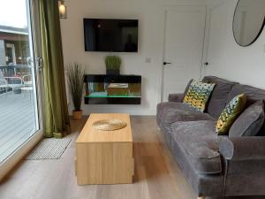 a living room with a couch and a coffee table at Chalet 176 Glan Gwna Park Caernarfon in Caeathro