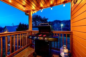 a barbecue grill on a deck on a porch at King Beds, Views, EasyRoads, PoolTable, Spa, Theater, Outdoor fun in Sevierville