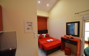 a small bedroom with a red bed and a television at Apartments Vesna Luxury ap 5 & 6 Paralia in Paralia Katerinis