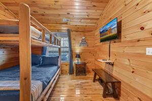 a bedroom with bunk beds in a log cabin at One Level, Pet Friendly, Huge Fenced in Yard, Views, EasyRoads, Pool Table, Spa, Theater, Outdoor fun in Sevierville