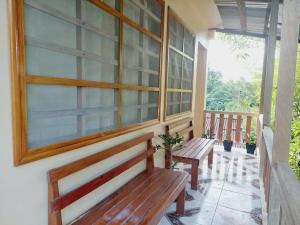 two benches on the porch of a house at Hostal Beru in Puerto Nariño