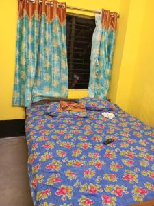 uma cama com um edredão azul e uma janela em SPG HOLIDAY em kolkata