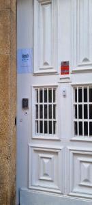 Una puerta blanca con dos ventanas en un edificio en Owls Hostel, en Oporto