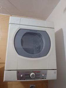 uma máquina de lavar roupa branca num quarto em Casa para Lollapalooza em São Paulo