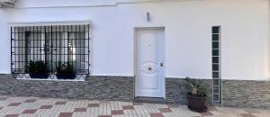 una puerta blanca en el lateral de un edificio en Casa Gloria, en Málaga