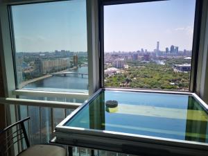 a room with a large window with a view of a city at Grand Alatau in Astana