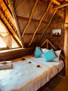 a bedroom with a bed with blue pillows at Villa 47 in Nuwara Eliya