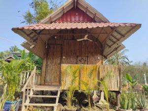 a small wooden building with a red roof at Odambang Village Homestay in Battambang