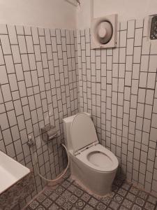 La salle de bains est pourvue de toilettes blanches et d'un lavabo. dans l'établissement Odambang Village Homestay, à Battambang