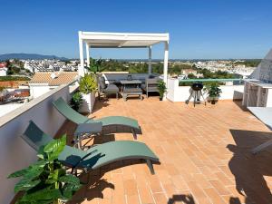 a patio with a table and chairs on a roof at Casa Rostam - Duplex avec Terrasses - Ferragudo in Ferragudo