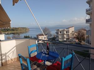 een tafel met een fles wijn op een balkon bij Angela's Seaview Apartment in Lefkandi Chalkidas