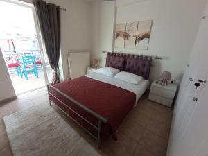een slaapkamer met een groot bed en een rode deken bij Angela's Seaview Apartment in Lefkandi Chalkidas