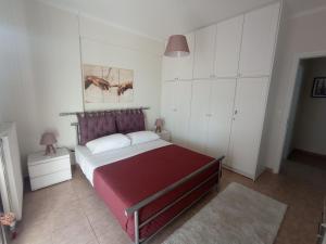 a bedroom with a large red bed with white cabinets at Angela's Seaview Apartment in Lefkandi Chalkidas