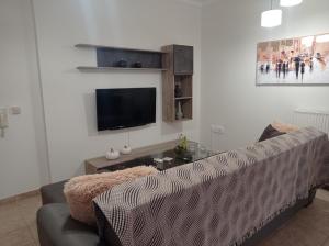 a living room with a couch and a flat screen tv at Angela's Seaview Apartment in Lefkandi Chalkidas