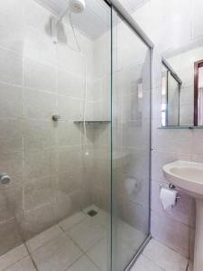 a bathroom with a glass shower and a sink at Hotel Netuno Beach in Fortaleza
