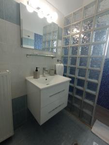 a bathroom with a white sink and a mirror at Angela's Seaview Apartment in Lefkandi Chalkidas +59 photos