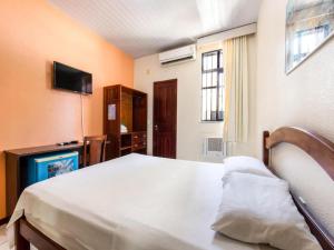 a bedroom with a bed and a tv and a television at Hotel Netuno Beach in Fortaleza