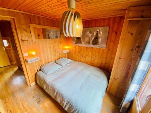 - une chambre avec un lit dans une pièce en bois dans l'établissement Chalet Orval - Chamonix Argentiere, à Chamonix-Mont-Blanc
