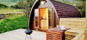una piccola cabina in legno con tavolo su una terrazza di South Kerry Glamping a Cahersiveen Altre 3 foto