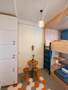 a room with a bunk bed and a table and two stools at Laca Hostel in Ho Chi Minh City