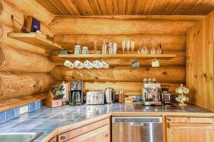 cocina con paredes de madera y encimera en Luxurious log cabin with private spa, en Lac-Supérieur