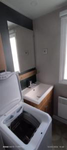 bagno con lavandino e specchio di mobil home 235 a Pont-Aven
