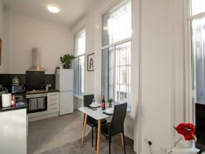 uma cozinha com mesa e cadeiras num quarto em Pass the Keys Modern Apartment in the Heart of Newcastle em Newcastle upon Tyne