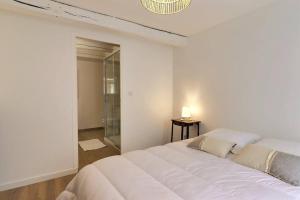 1 cama blanca grande en una habitación con espejo en La Dolce Vita, jolie maison familiale, en Troyes