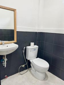a bathroom with a toilet and a sink at The Continental Hostel El Nido in El Nido
