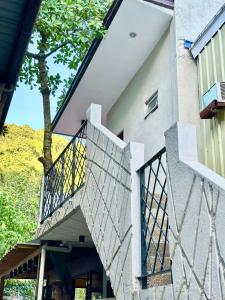 a house with a staircase leading up to a building at The Continental Hostel El Nido in El Nido