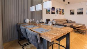 VacationClub - Awanport Apartament 14 B في غدينيا: غرفة طعام مع طاولة مع كؤوس للنبيذ