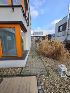 une maison avec une porte orange et une passerelle dans l'établissement MARIE, à Zlín