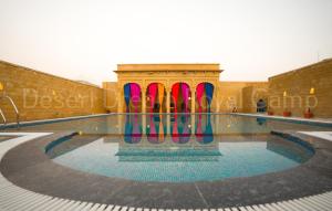 a pool with colorful surfboards in the middle of a building at Desert Dream Royal Camp with Pool in Jaisalmer