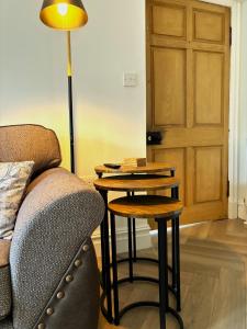 a living room with a table and a couch and a lamp at The Gate Lodge in Helensburgh