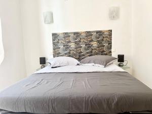 een slaapkamer met een groot bed met 2 kussens bij Charme et Confort in Villeneuve-lès-Béziers