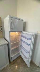 an empty refrigerator with its door open in a kitchen at Dar elrayen in Tozeur