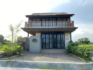 a small house with a balcony on top of it at Baku living villa in Ngaglik
