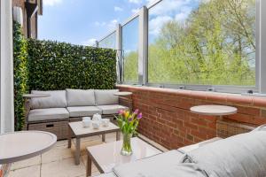 a patio with couches and tables and a large window at Exe Riverside Retreat Holiday Home in Exeter
