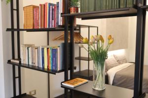 um vaso de flores sobre uma mesa com livros em Casa moderna nel centro di Imola em Imola