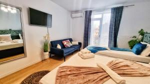 a living room with a bed and a couch at KYD VILA - Studiouri si Apartamente la 100m de Plaja Debarcader in Eforie Nord