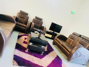 sala de estar con sofás de cuero y TV en AULNES RESIDENCE HOTEL en Cotonú