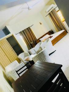 uma sala de estar com mesa e cadeiras em AULNES RESIDENCE HOTEL em Cotonou