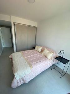 a bedroom with a bed and a side table at Zona Güemes 2 ambiente N 503 in Mar del Plata +22 photos