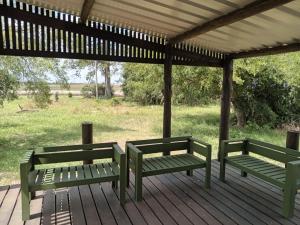 twee groene banken op een houten terras bij Casa de campo en Los Cerrillos in Los Cerrillos