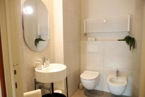 a bathroom with a sink and a toilet and a mirror at Casa moderna nel centro di Imola in Imola +16 photos
