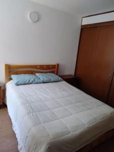 una camera con un grande letto con testiera in legno di Apartamento Amoblado a Bogotá