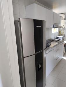 a kitchen with a black and white refrigerator at Apartamento Amoblado in Bogotá